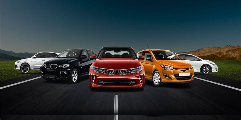 Five cars aligned on a straight highway with mountains in the distance; red sedan in the center flanked by a black SUV, orange hatchback, and white cars on each side.